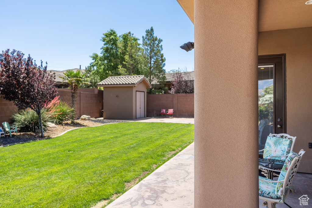 Fenced backyard with a shed and a patio