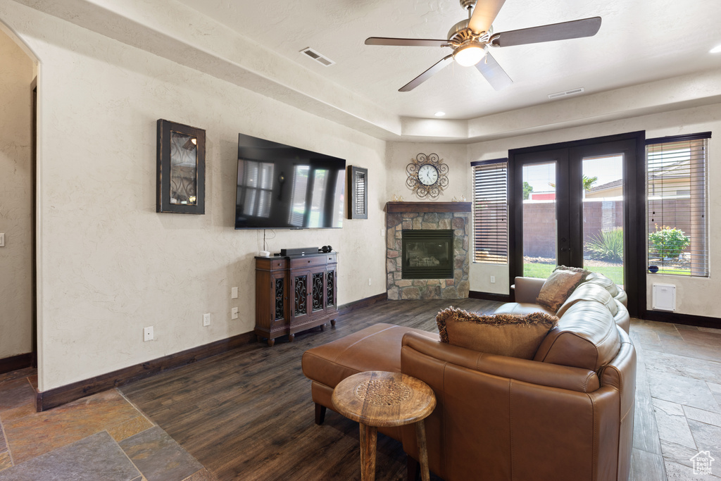 Living area with stone tile floors, a fireplace, a ceiling fan, recessed lighting, and arched walkways