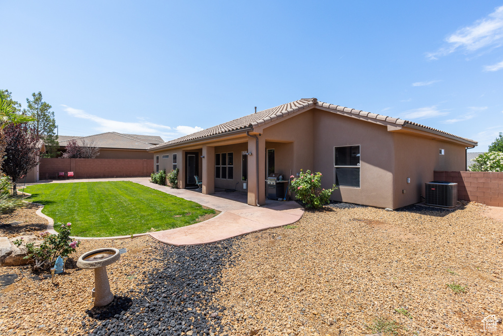 Rear view of property with a fenced backyard, stucco siding, a tile roof, and a patio