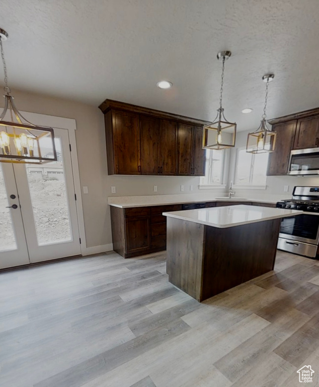 Kitchen featuring appliances with stainless steel finishes, a chandelier, dark brown cabinets, a center island, and recessed lighting
