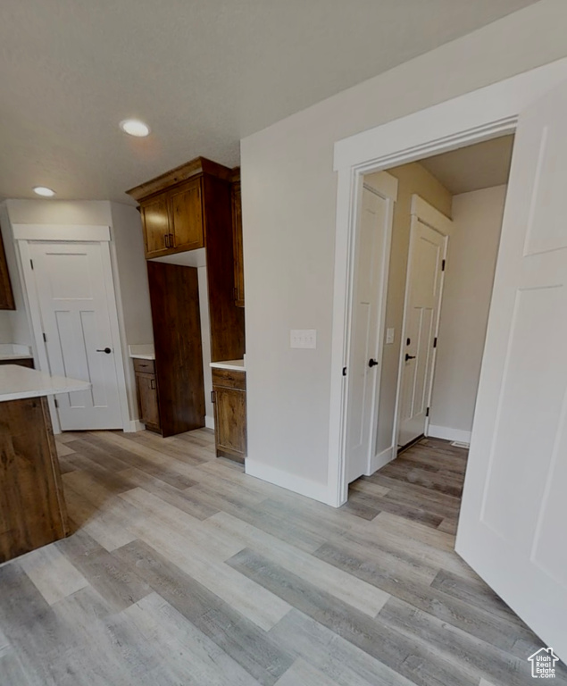 Kitchen featuring recessed lighting, light wood-style floors, light countertops, and brown cabinets