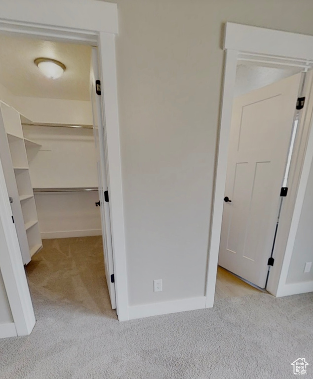 Unfurnished bedroom featuring carpet floors, a spacious closet, and a closet
