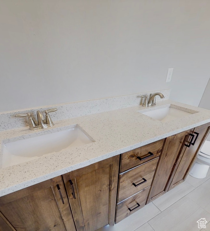 Bathroom with double vanity and tile patterned floors