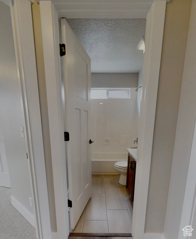 Full bathroom with vanity, shower / bath combination, tile patterned flooring, and a textured ceiling