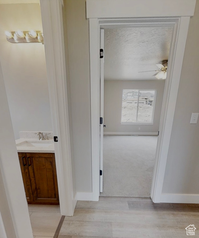 Corridor featuring light wood-type flooring and baseboards