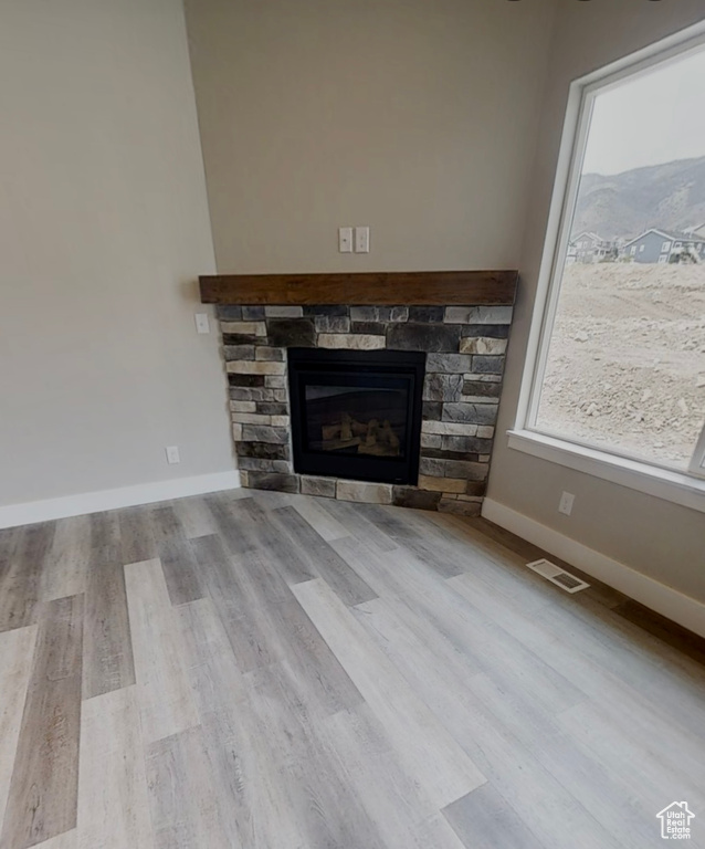 Detailed view of wood finished floors and a fireplace
