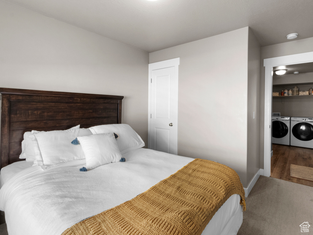 Carpeted bedroom with washer and clothes dryer and baseboards