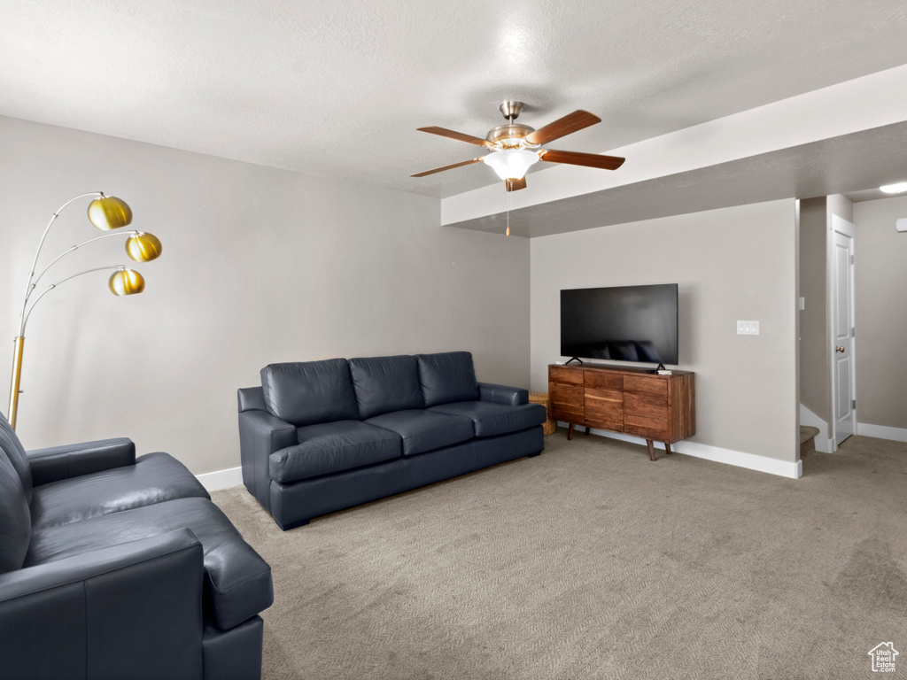 Living room featuring carpet floors and a ceiling fan