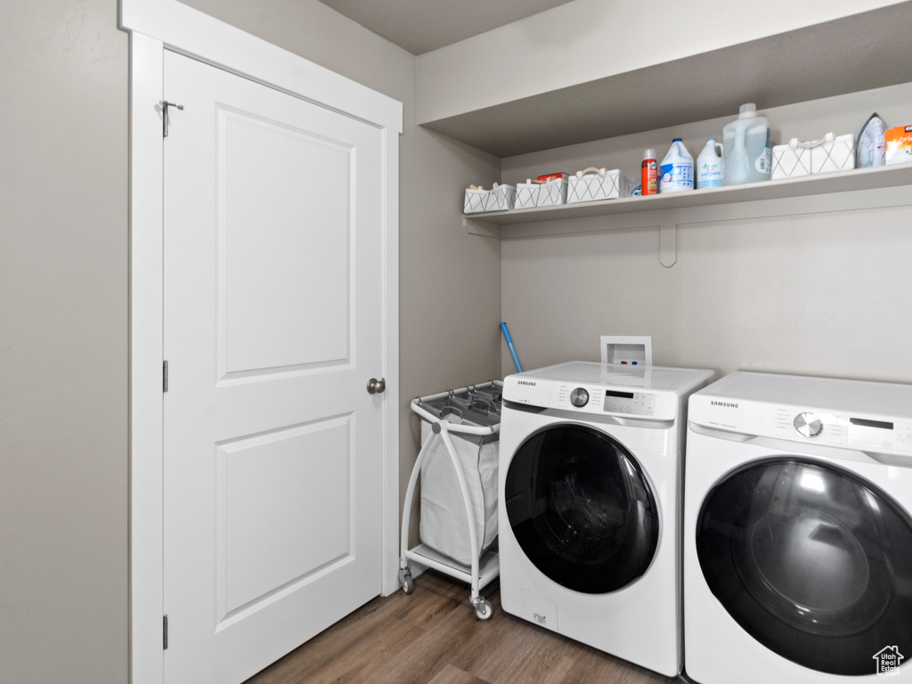 Laundry area with washer and dryer and wood finished floors
