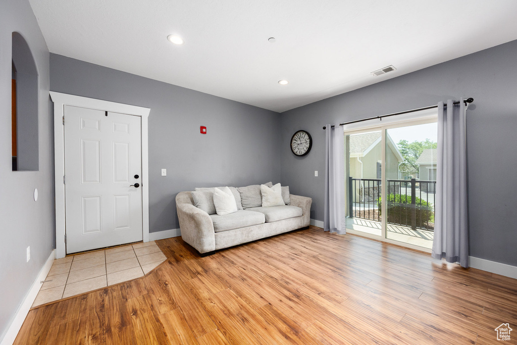 Living area with arched walkways, light wood-type flooring, and recessed lighting