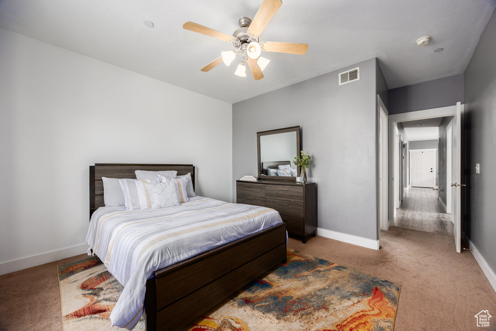 Carpeted bedroom featuring baseboards and a ceiling fan