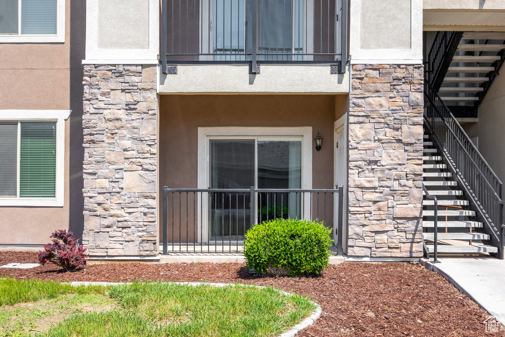 Property entrance featuring stone siding and stucco siding