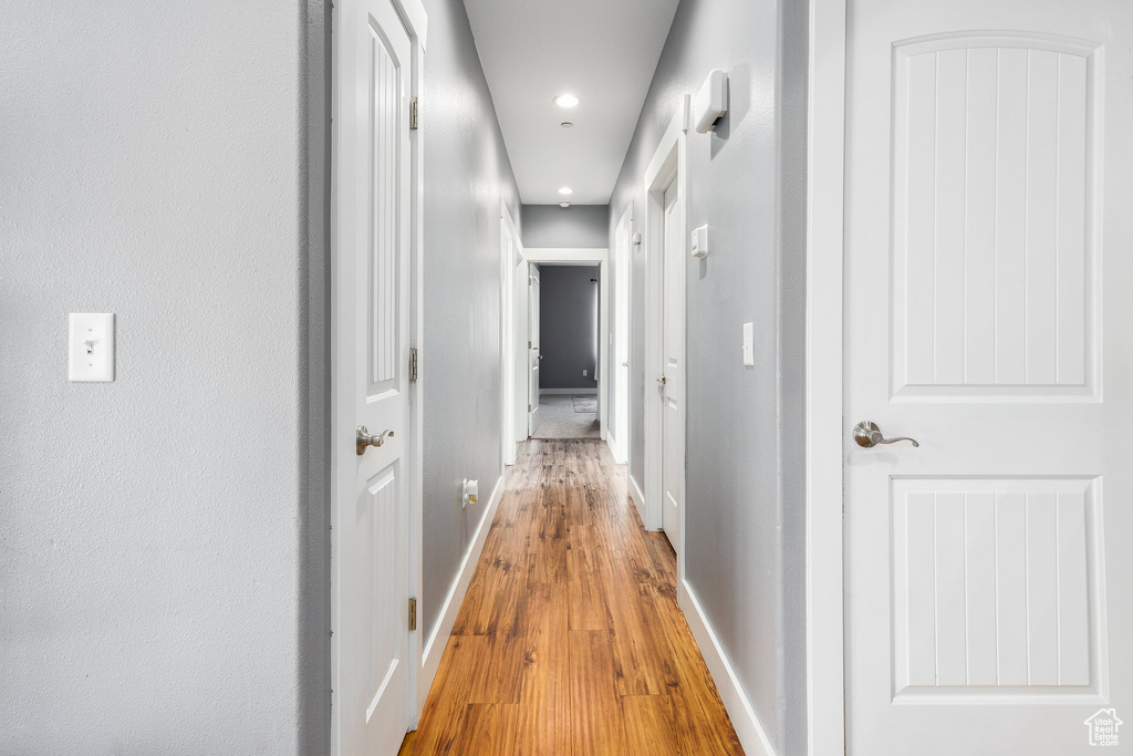 Corridor featuring light wood finished floors and recessed lighting