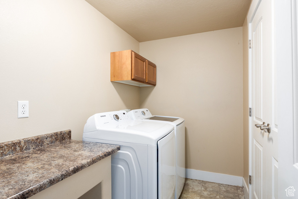 Laundry room with washer and clothes dryer and cabinet space