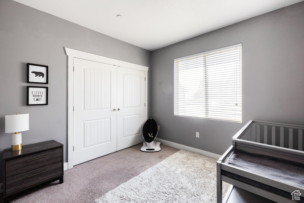 Carpeted bedroom featuring a closet and baseboards