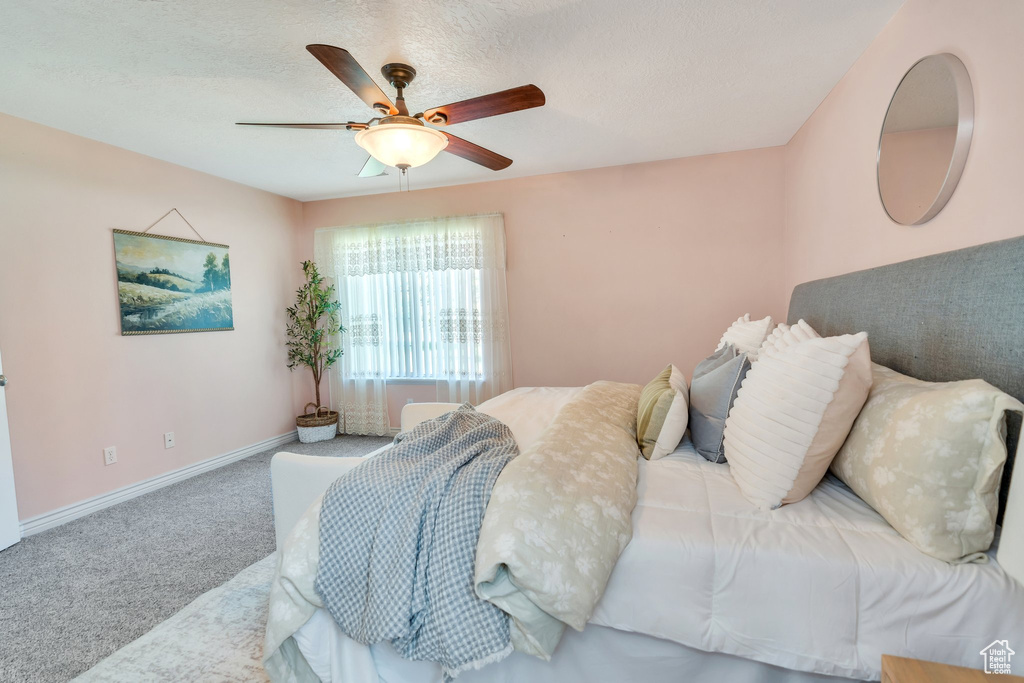 Carpeted bedroom featuring baseboards and ceiling fan