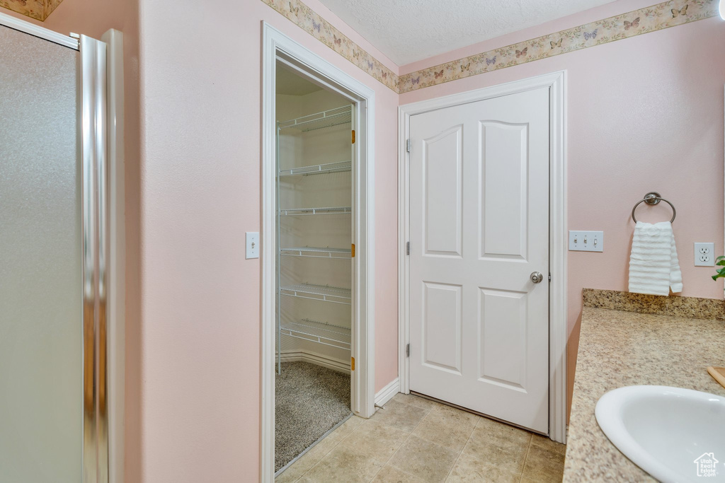 Full bathroom with a stall shower, vanity, and a walk in closet