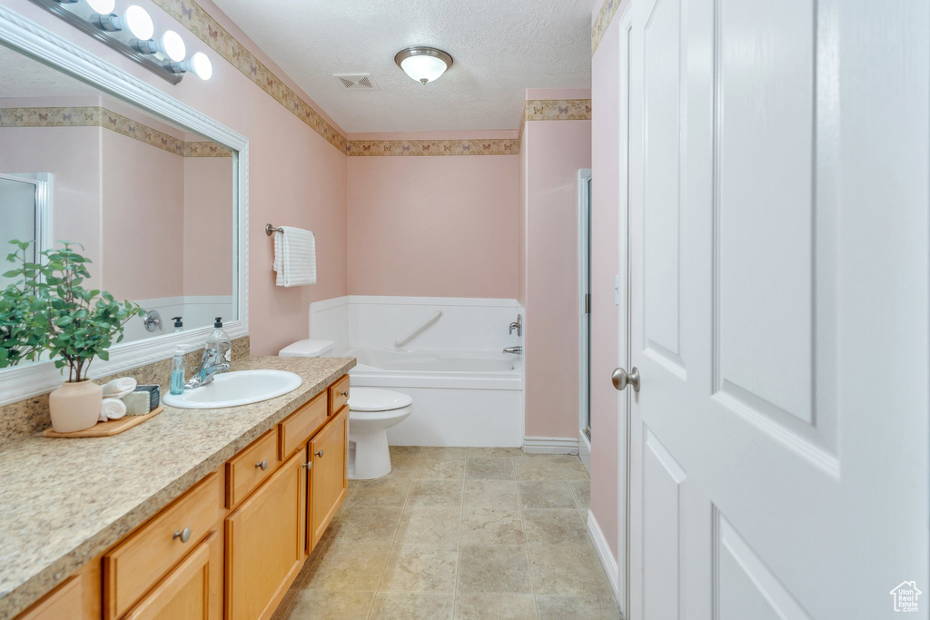 Full bathroom with vanity, a bath, a textured ceiling, and an enclosed shower