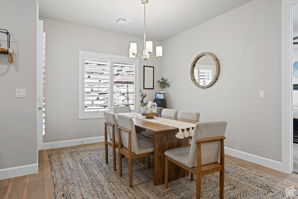 Dining space with light wood-style floors and a chandelier
