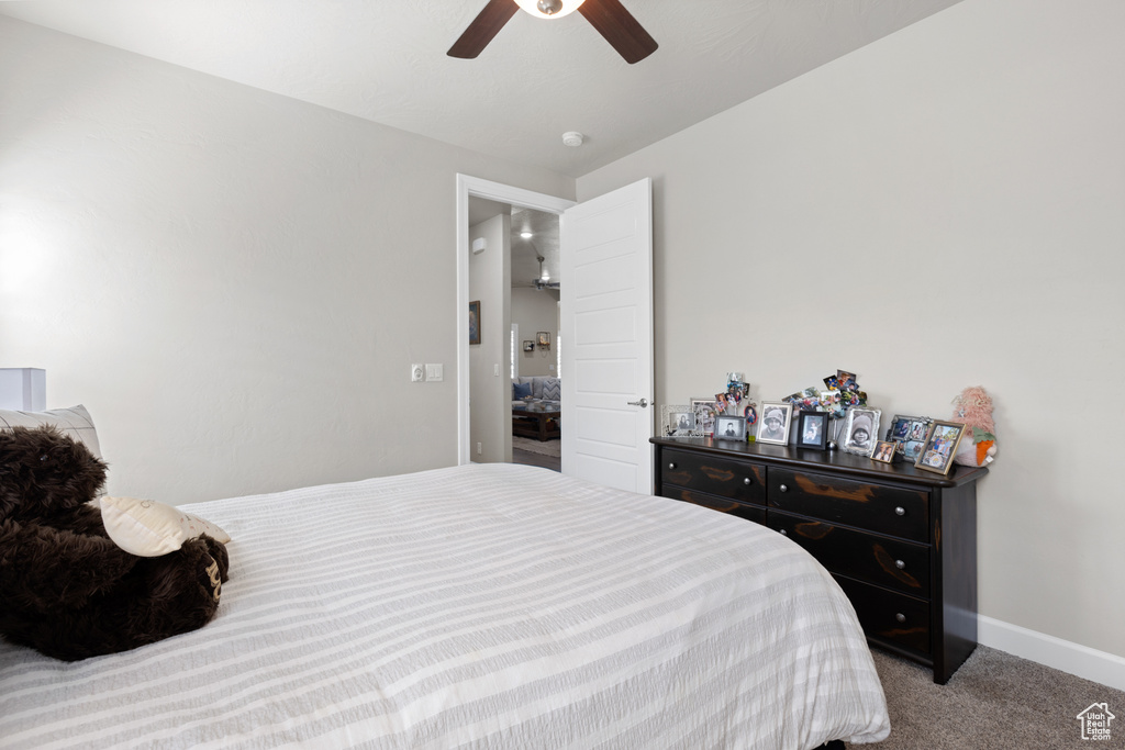 Carpeted bedroom with baseboards and a ceiling fan