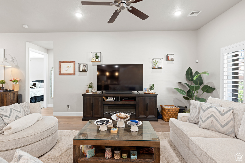 Living area with a ceiling fan, light wood-style floors, and recessed lighting