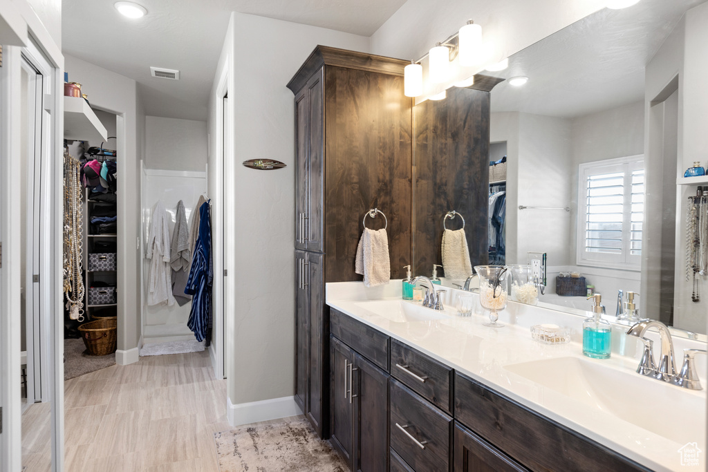 Full bath with double vanity and a walk in closet
