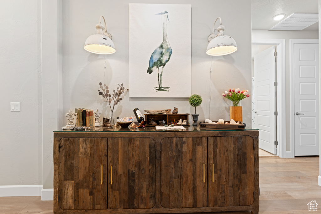 Bar with light wood-type flooring and baseboards