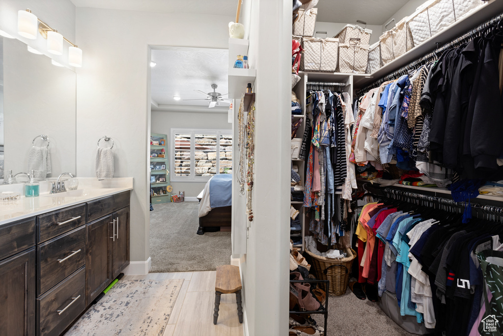 Walk in closet with ceiling fan and a sink