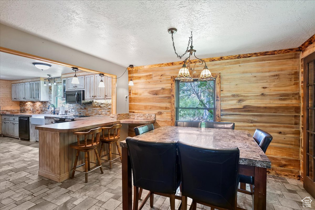 Dining area with a textured ceiling and wooden walls
