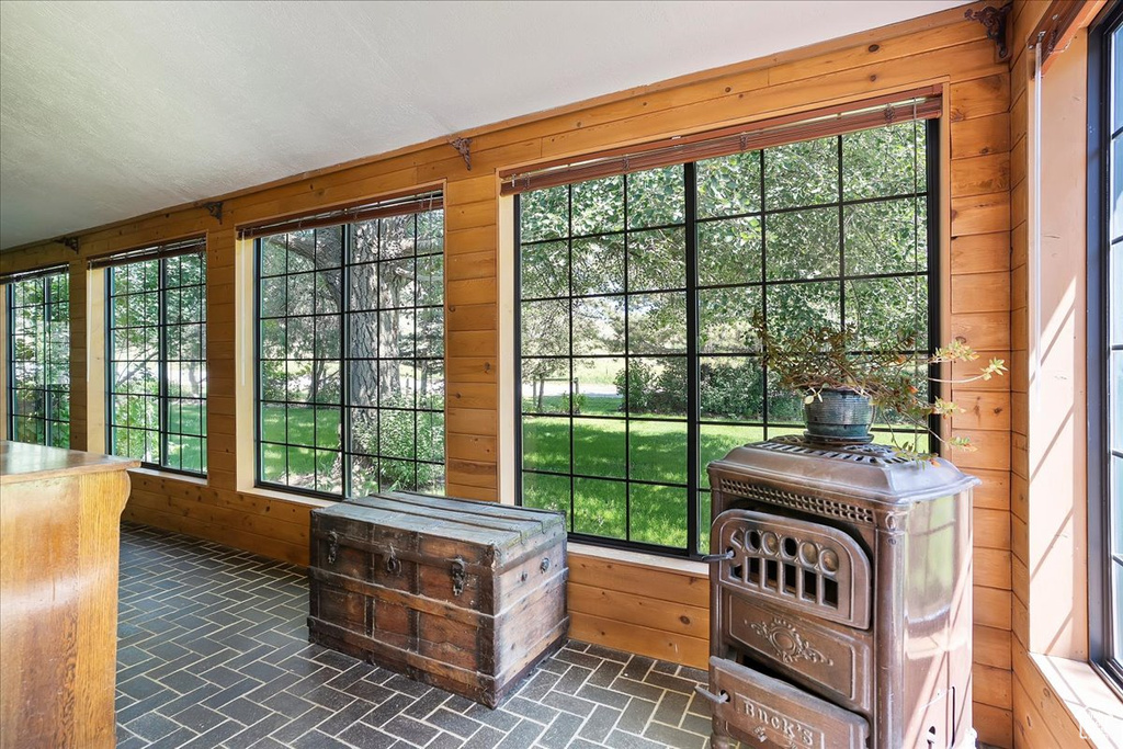 Doorway to outside featuring brick patterned flooring and wood walls