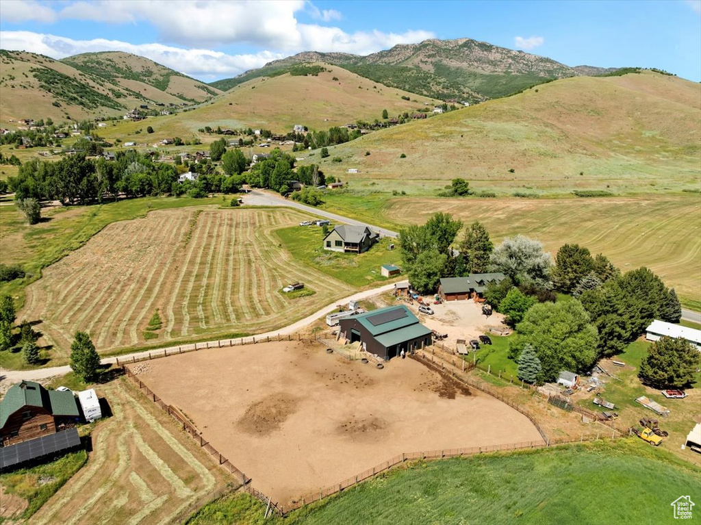Aerial view of property and surrounding area featuring rural landscape and a mountainous background