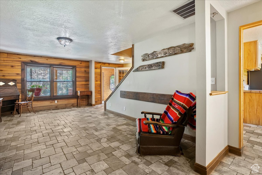 Sitting room with wooden walls and a textured ceiling