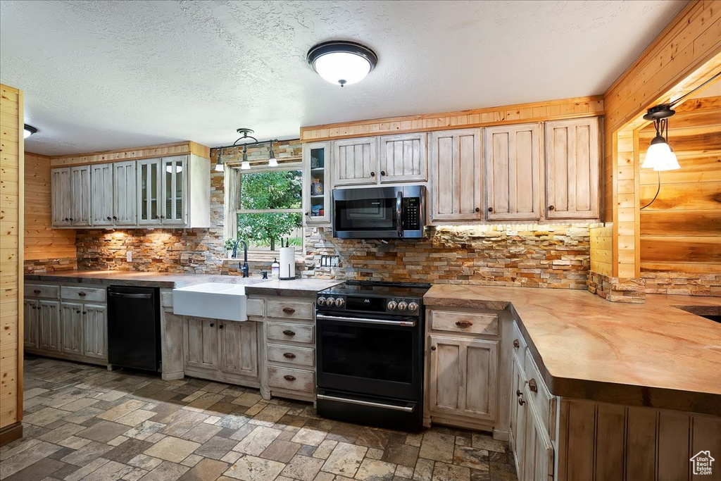 Kitchen with electric stove, black dishwasher, decorative backsplash, glass insert cabinets, and a peninsula