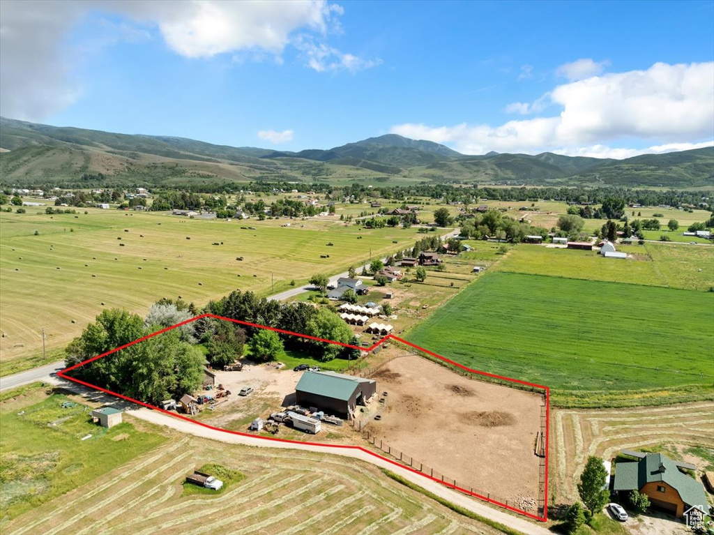Aerial view of sparsely populated area featuring property parcel outlined and a mountain backdrop