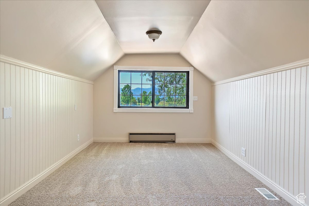 Additional living space featuring baseboard heating, vaulted ceiling, and carpet
