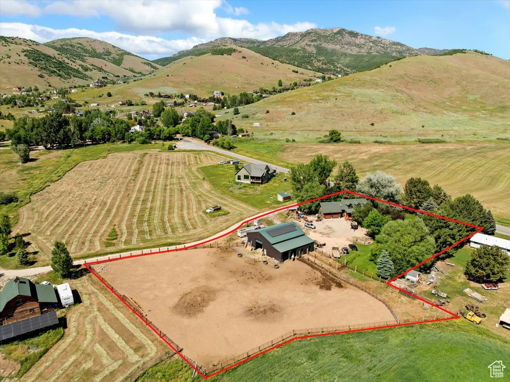 Aerial view of sparsely populated area featuring property boundaries highlighted and a mountain backdrop