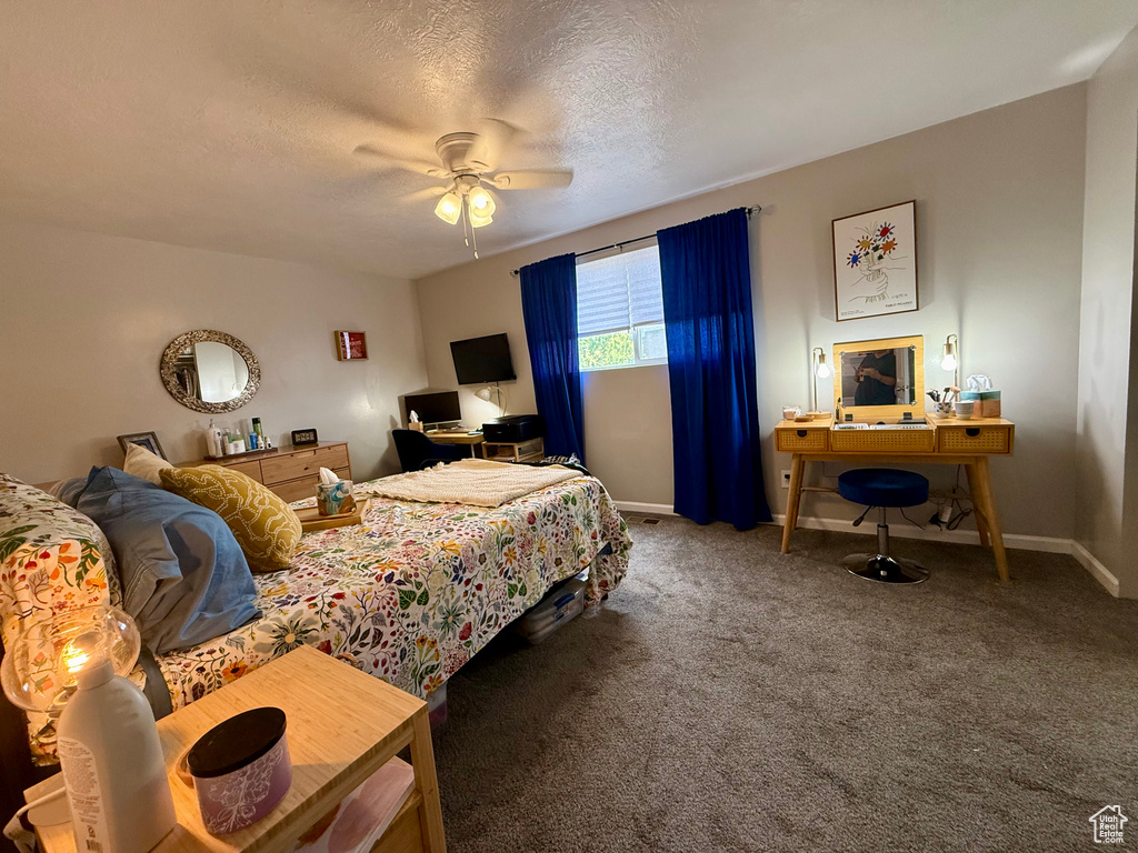 Bedroom featuring an office area, carpet floors, ceiling fan, and a textured ceiling