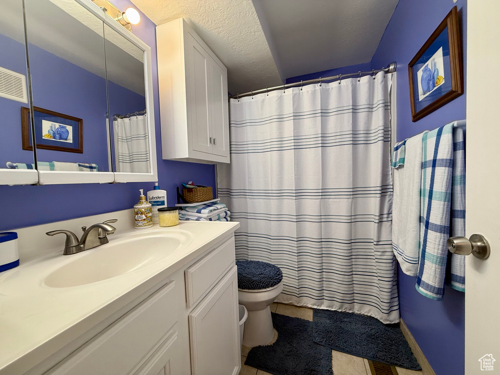 Full bathroom with vanity, tile patterned floors, and curtained shower
