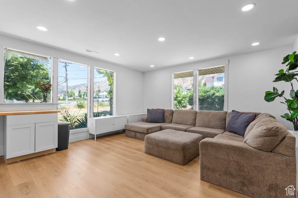 Living room with light wood finished floors and recessed lighting