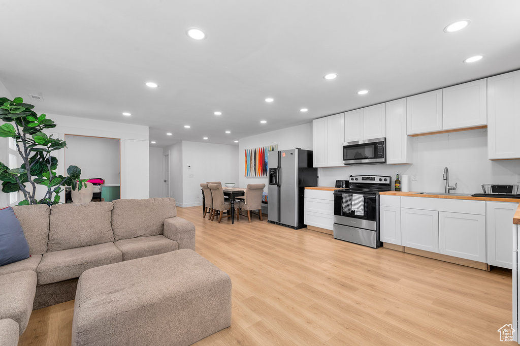 Living room with recessed lighting and light wood-style flooring
