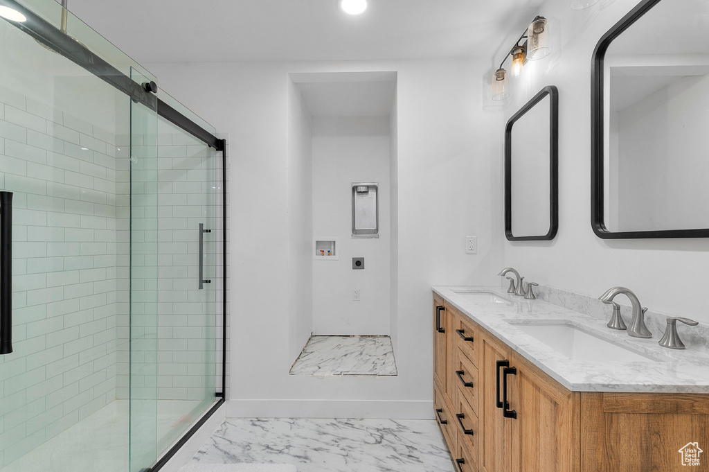 Bathroom with marble finish floors, a stall shower, double vanity, and recessed lighting