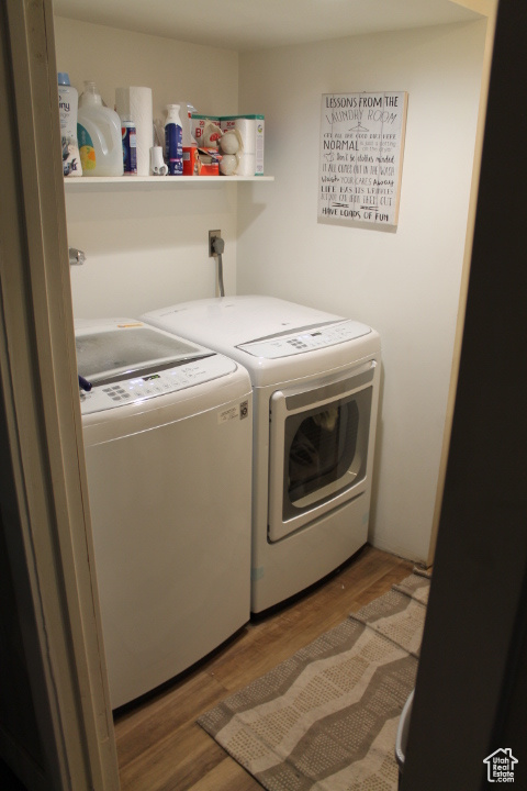 Laundry area featuring washing machine and clothes dryer and wood finished floors