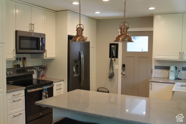 Kitchen with stainless steel appliances, tasteful backsplash, recessed lighting, white cabinets, and light stone counters
