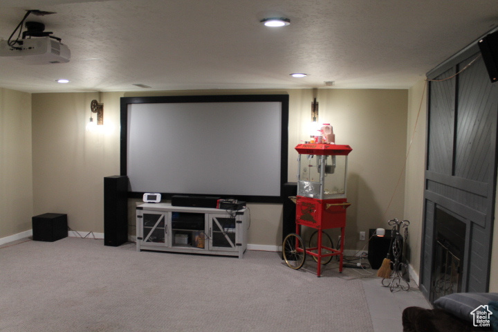 Carpeted home theater room featuring a fireplace and recessed lighting
