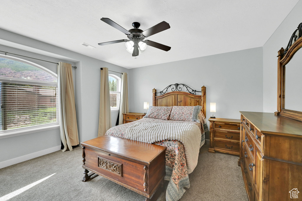 Carpeted bedroom featuring baseboards and a ceiling fan
