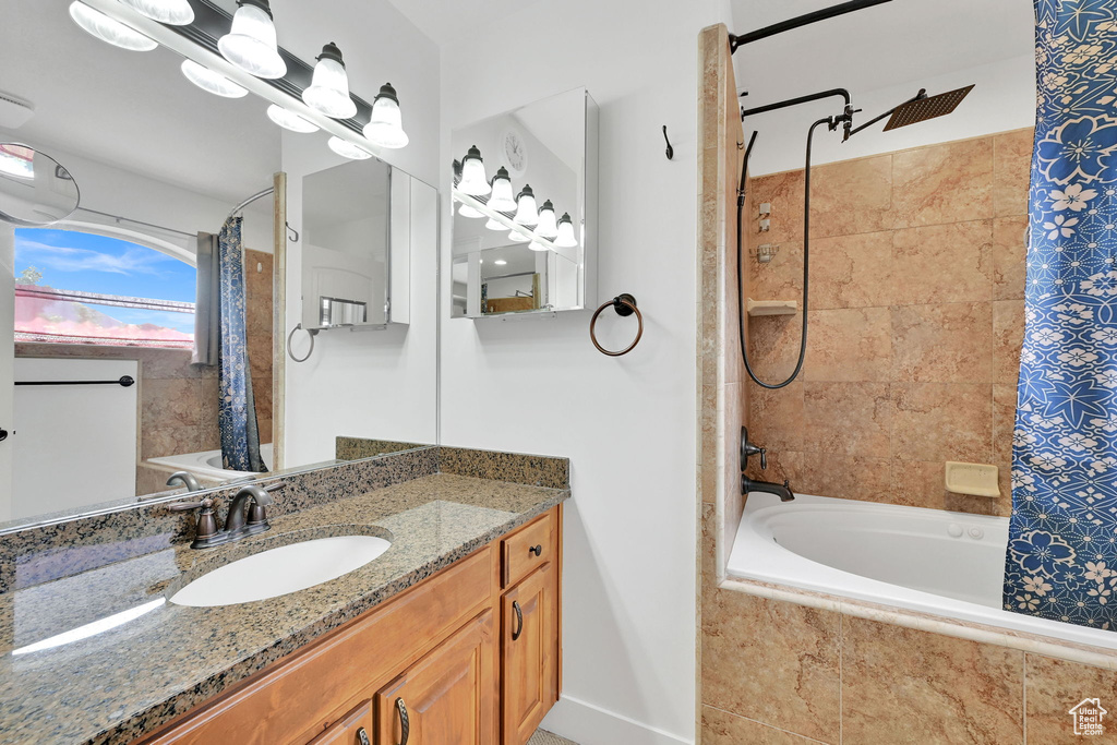 Full bath with tiled shower / bath combo and vanity