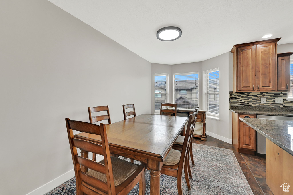 Dining room with baseboards and dark stone finish floors