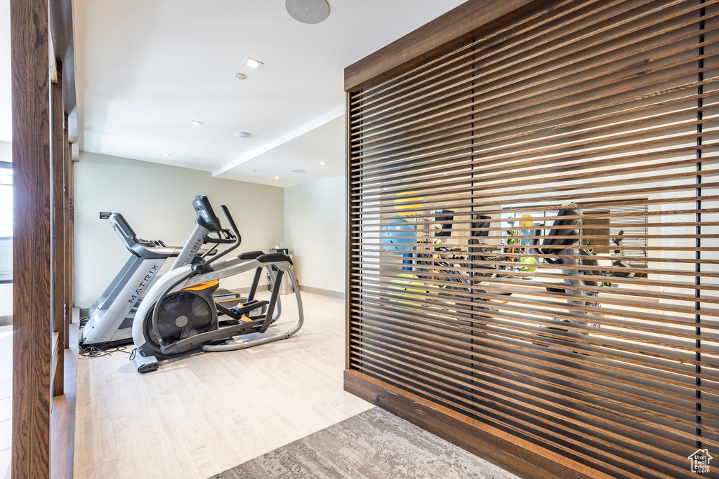 Exercise area with wood finished floors and baseboards