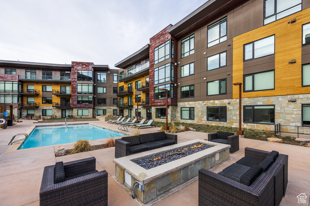 Community pool featuring an outdoor fire pit and a patio