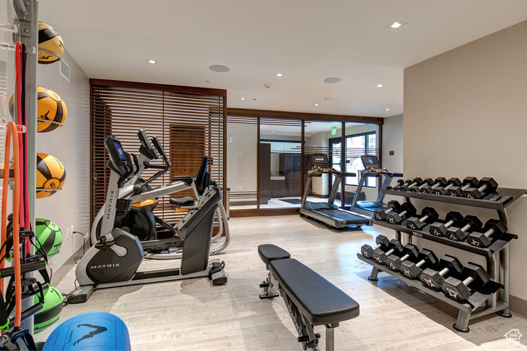 Workout area featuring wood finished floors and recessed lighting